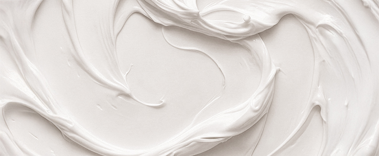 Vier lachende Frauen unterschiedlichen Alters vor hellem Hintergrund.